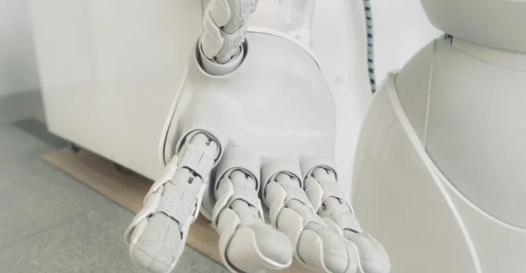 Main de robot blanche tendue paume ouverte, illustration d'un comparatif d'assistants IA