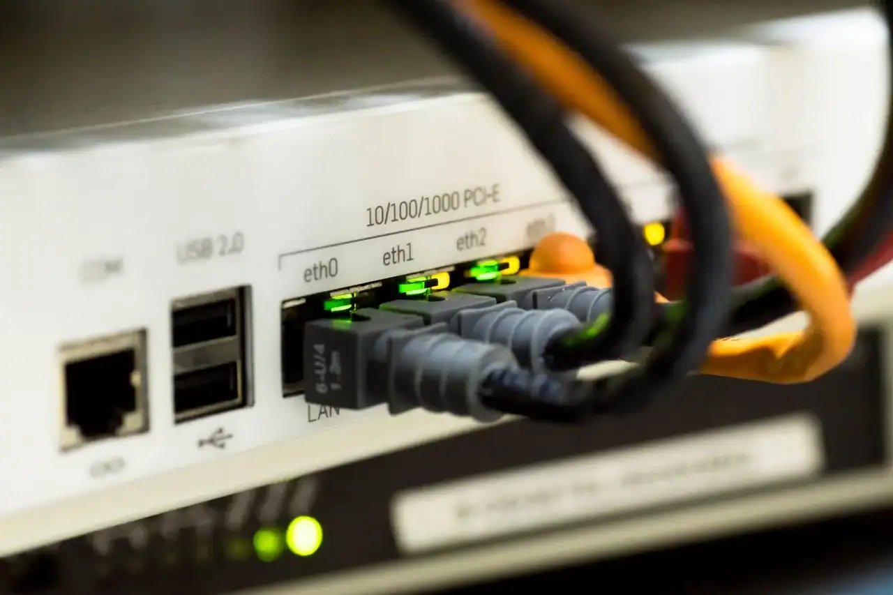 Câbles Ethernet branchés sur les ports d'un équipement réseau aux voyants verts
