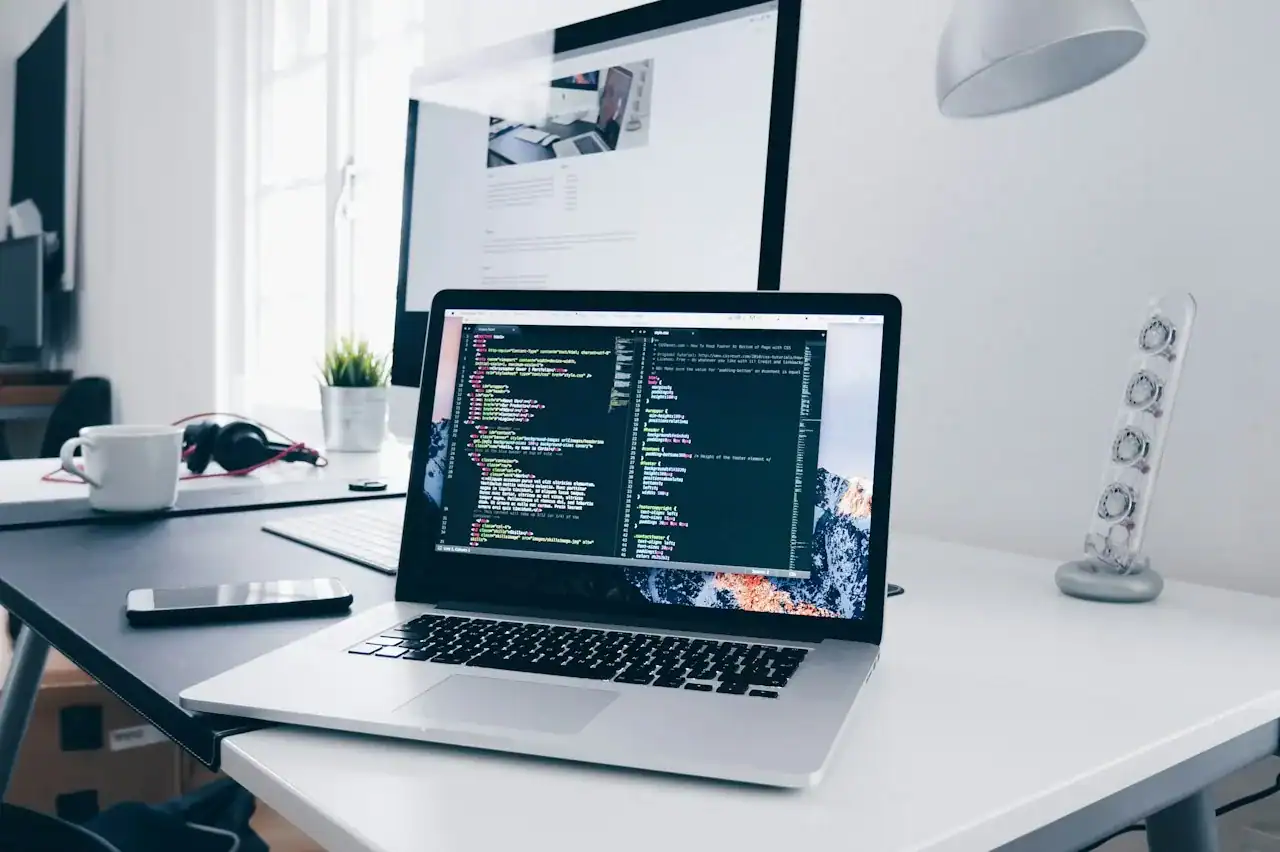 Ordinateur portable affichant du code sur un bureau, illustration d'un hébergement cloud pour développeurs