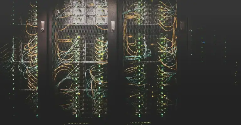 Baies de serveurs et câbles réseau orange et bleus dans un datacenter
