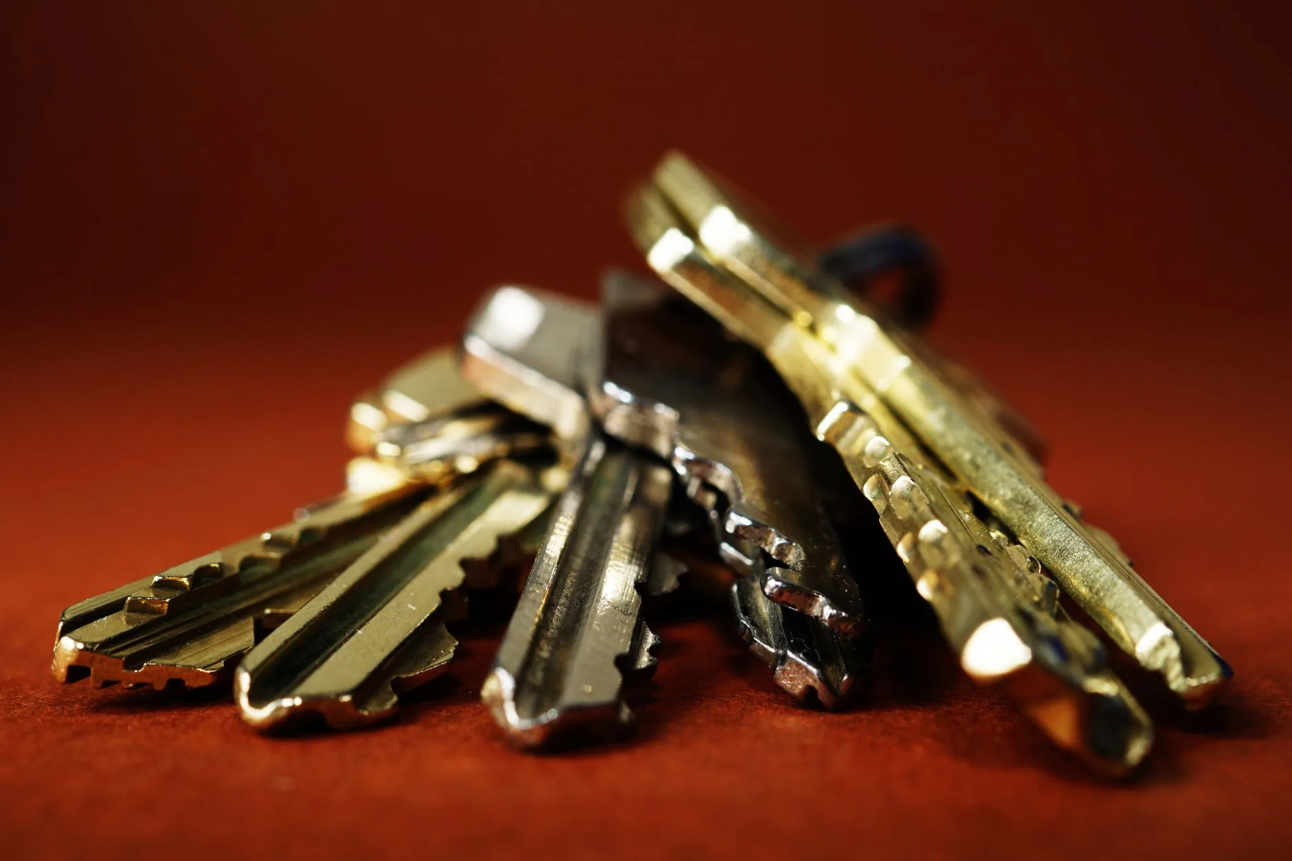 Pile de clés métalliques sur fond rouge symbolisant le remplacement des mots de passe par les passkeys