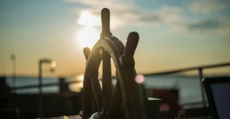 Barre à roue en bois d'un navire au coucher du soleil, image du timonier dont Kubernetes tire son nom