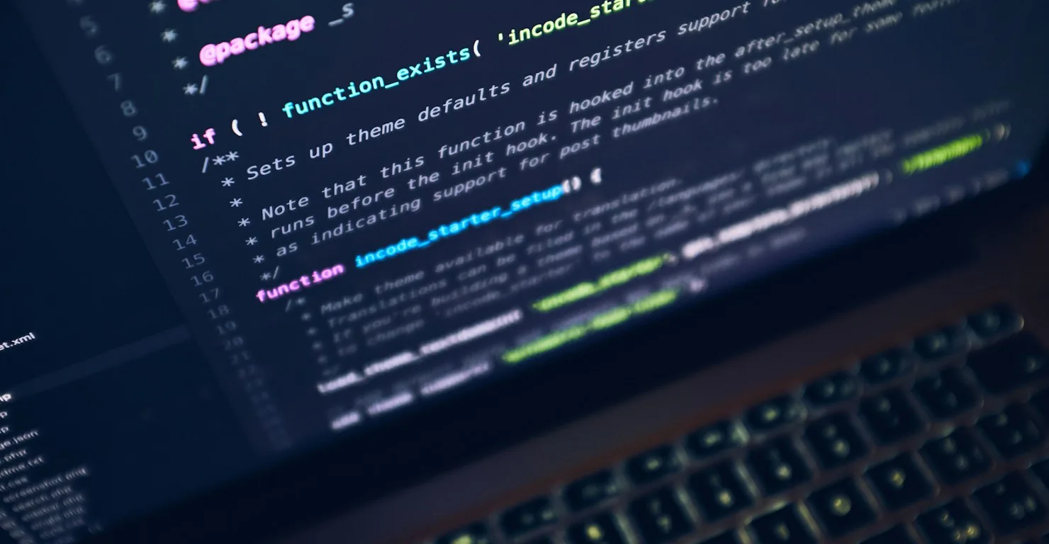 Gros plan sur un ordinateur portable affichant du code, illustration du choix d'un laptop pour développeur