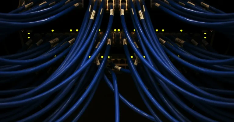 Câbles réseau bleus branchés sur une baie de serveurs, image du rôle d'aiguillage d'un reverse proxy