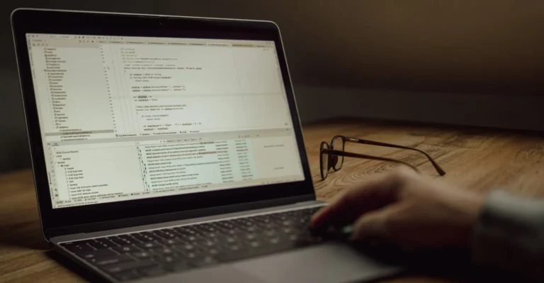Ordinateur portable affichant du code sur un bureau en bois